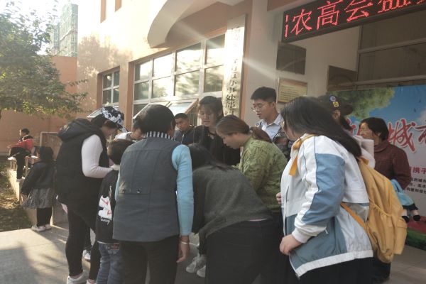 志愿者正在通过宣传手册科普新冠肺炎知识.jpg